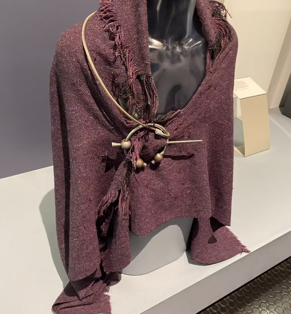 Iron Age red mantle with penannular brooch photographed at the Ulster Museum Belfast