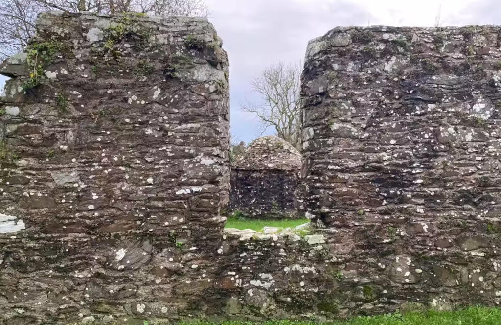 Photograph of behive well at Struell Wells framed in the gap of a wall, associated with St. Patrick in Northern Ireland, taken by Daniel Kirkpatrick